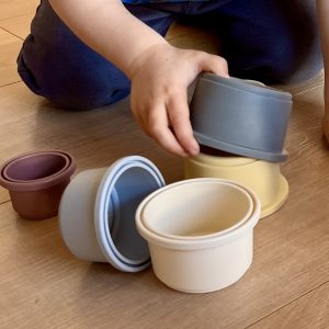 a child playing with stacking cups